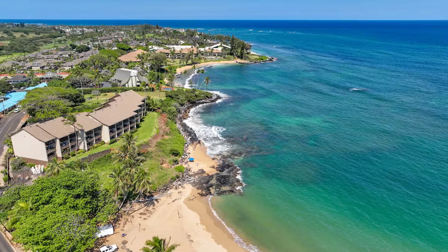 Aerial over the beach and cove beside Wailua Bay View